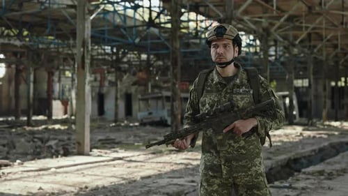 Armed Man in Military US Uniform Walking on Industrial Plant