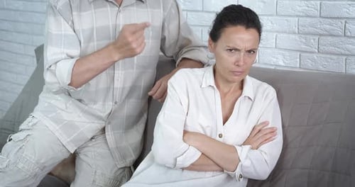 Upset Woman Ignoring Arguing Man on Sofa