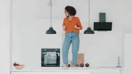 Woman Joyfully Dancing on Kitchen Counter