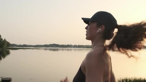 Healthy Young Woman Breathes Hard After Jogging in the Park During the Sunrise