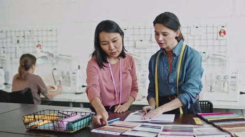 Junge Frauen entwerfen Kleidungsstücke im Studio