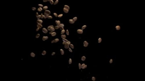 Un grain de café tombant au ralenti isolé sur fond noir