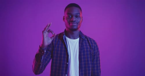 Young Man Makes Okay Gesture with Fingers