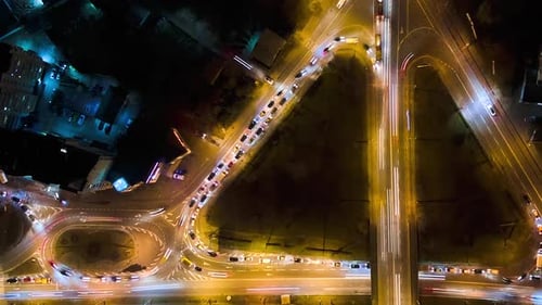 Aerial View of Road Intersection with Fast Moving Heavy Traffic at Night