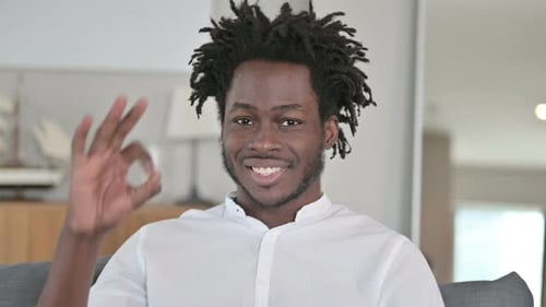 Young Adult Gives 'OK' Gesture to Camera