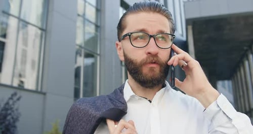 Office Manager in Glasses which Talking on Phone Near City modern building
