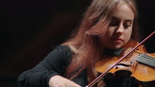 Young Female Fiddler is Learning to Play Violin or Viola in Philharmonic Hall