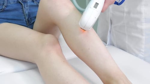 Therapist Makes Laser Hair Removal on Visitor Leg Close View