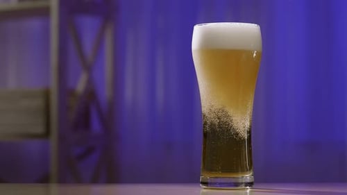 Beer Pouring Into Glass with Foamy Head
