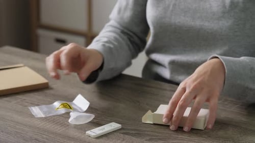 Person Prepares COVID-19 Rapid Antigen Test at Home