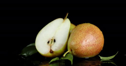 Whole and a Piece of Fresh Pear with Leaves Slowly Rotate.
