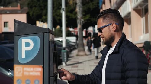 Close Up Shot of a Man Inserting a Parking Lot Ticket at an Automated Pay Machine