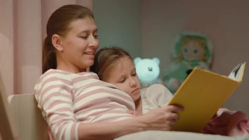 Mother Reading a Bedtime Story to Daughter at Home
