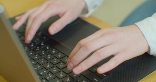 Manos escribiendo en el teclado del ordenador, cámara en movimiento, mujer de negocios trabajando en un ordenador portátil en la oficina.