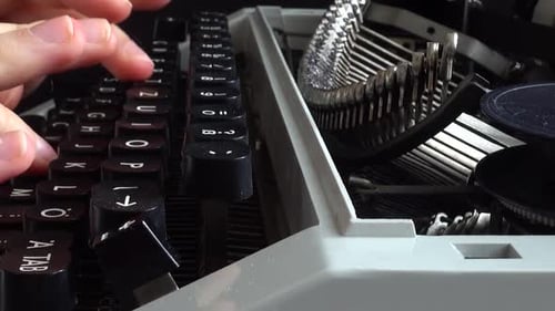 The girl is typing on a retro typewriter.