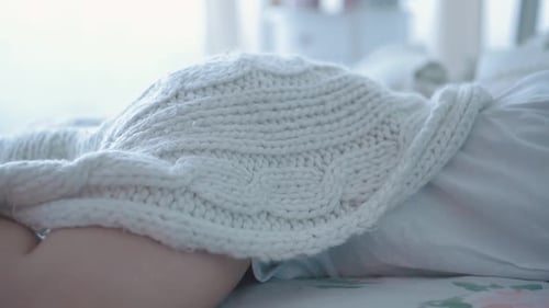 Woman Sleeping Peacefully Underneath a Knit Blanket