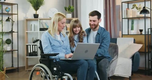 Family Gathers Around Laptop at Home Together
