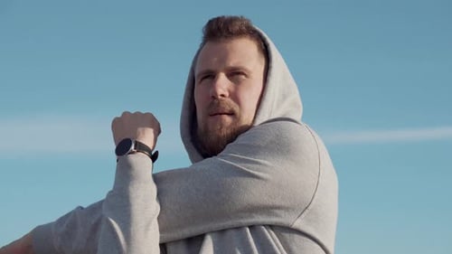 Man Stretching Outdoors on Sunny Day