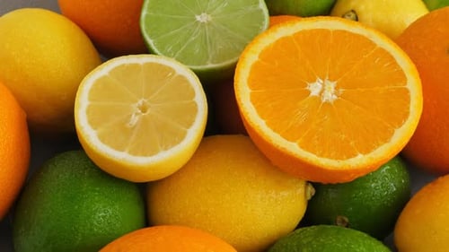 Halb geschnittene saftige Limette auf Zitrusfruchthintergrund, viel Zitrone, Orangen und Limetten Draufsicht