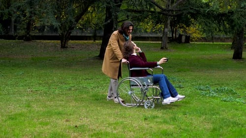 wheelchair user -woman with paraplegia accompanied by her boyfriend at park