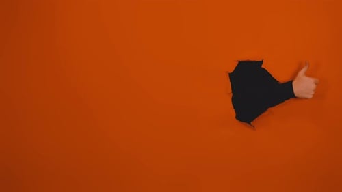 Hand Giving Thumbs Up Through Hole