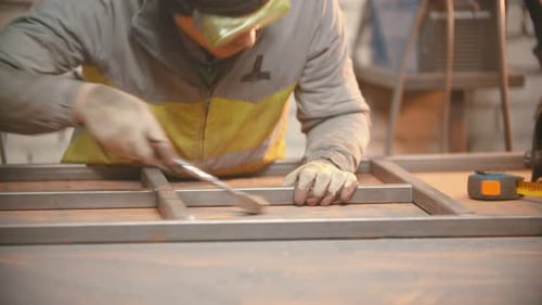 Ein Arbeiter überprüft einen Metallrahmen auf Haltbarkeit
