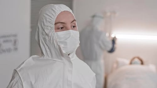 Healthcare Worker Removing Face Shield in Hospital