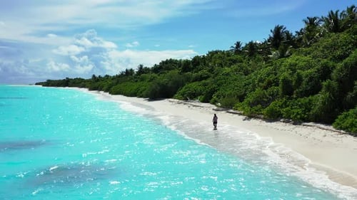 Lady alone happy and smiling on perfect shore beach lifestyle by clear water with white sandy backgr