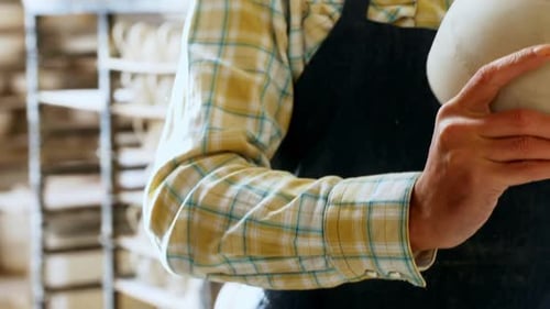 Potter Inspects Clay Bowl in Workshop