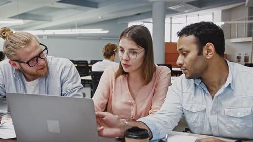 Team Works Together at Desk in Office