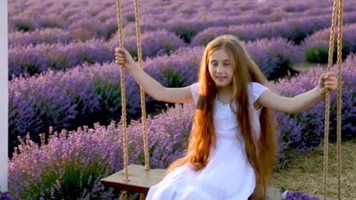 Girl Riding a Swing in a Lavender Field