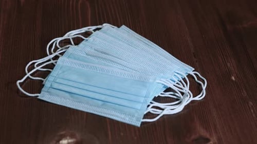 Stacks of blue face masks on dark wood table