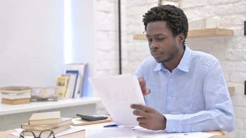 Adult Reviewing Financial Documents in Office Setting