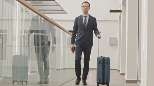 Man in Suit with Suitcase Walking along Airport