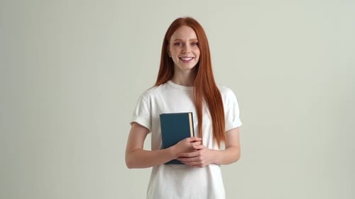 Smiling Woman Holding a Book Indoors