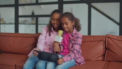 Two Girls Singing Karaoke Together Indoors