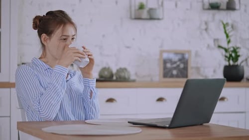 Smiling Female Watching Funny Video on Laptop