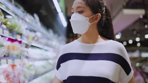 asian female woman wearing protective face mask in groceries store