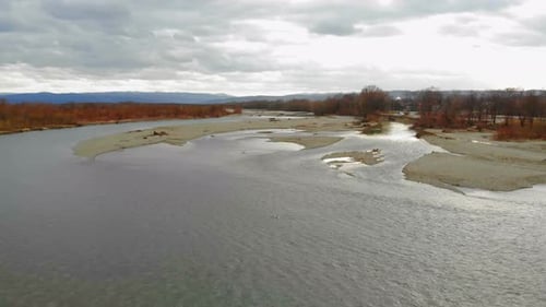 Low flying drone over the river with rocks