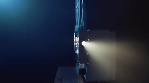 Vintage Film Projector Shining in Dark Room