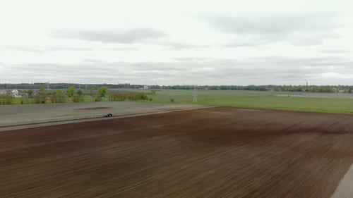 Tractor Tilling Farmland with Birds Following