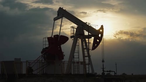 Oil Mining an Oil Rig in the Field Pumps Out Oil View of an Oil Rig at Sunset Resource Extraction