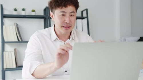 Man Working at Laptop Computer in Office