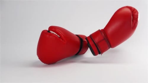 Par de guantes de boxeo de cuero rojo cayendo y rebotando aislados en blanco