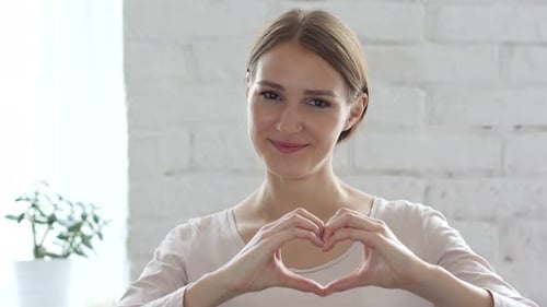 Smiling Woman Making Heart Shape With Hands