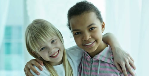 Two Young Girls Smiling and Hugging
