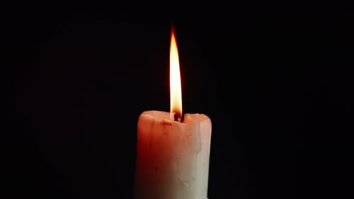 The showcases of colorful single candlelight on black background with the effect of light and slow m