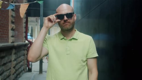 Bearded Man Walking Down City Alley in Sunglasses