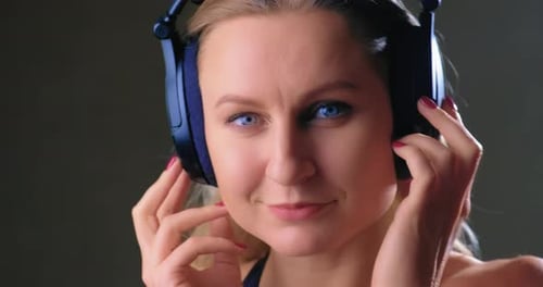Woman Adjusting Wireless Headphones in Close Up Shot