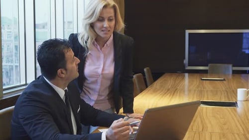 Business Meeting with Colleagues Collaborating on Laptop